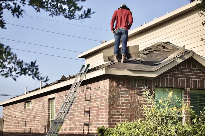 Professional roofer working on a residential roof in Camp Massapoag